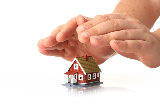 House insurance. Hands and small house over white.